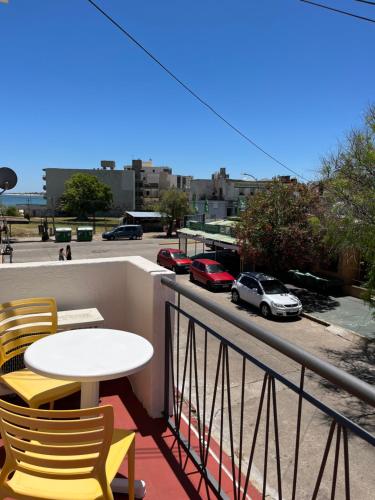 a table and chairs on a balcony with a view of a parking lot at Hotel Tamariz in Piriápolis