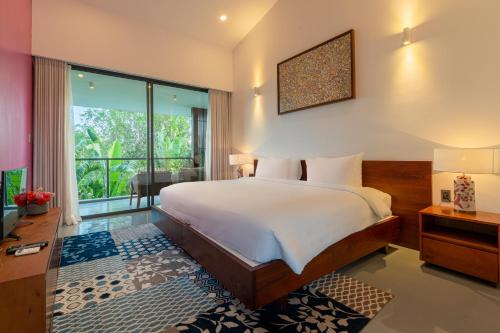 a bedroom with a bed and a large window at Akala Villa Hoi An in Hoi An