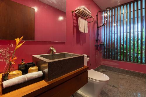een roze badkamer met een wastafel en een toilet bij Akala Villa Hoi An in Hội An