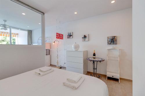 Habitación blanca con cama y nevera. en Sueño Azul FRONT MER, en Callao Salvaje