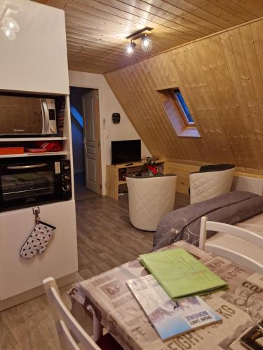Il comprend une cuisine et un salon avec une table et un four micro-ondes. dans l'établissement la maison des fleurs studio, à Le Mont-Dore
