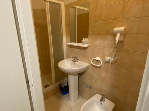 y baño con lavabo y espejo. en Hotel La Pergola, en Loano