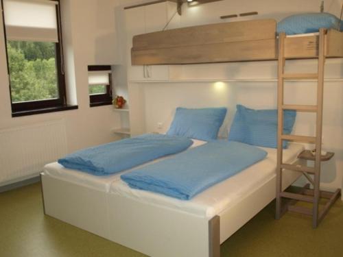 ein Schlafzimmer mit einem Etagenbett mit blauen Kissen in der Unterkunft Junges Hotel Annaberg in Annaberg