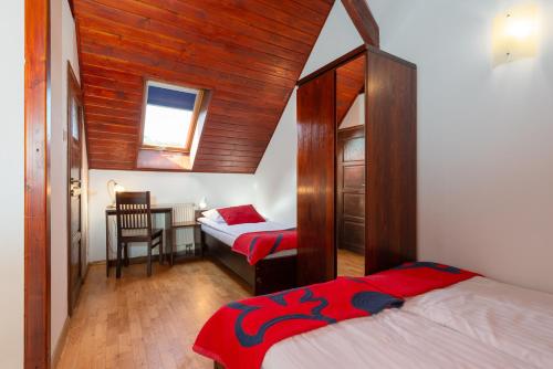 a bedroom with two beds and a table with a chair at Hotel Beskid in Milówka