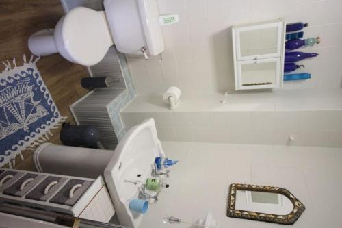 a white bathroom with a sink and a mirror at Blue Skies in Deal