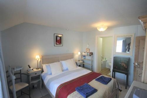 a bedroom with a bed and a desk and a television at Blue Skies in Deal