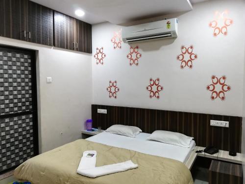 Hotel Shiv Regency في Kukma: غرفة نوم بسرير ومكيف على الحائط
