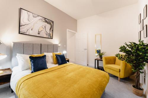 a bedroom with a yellow bed and a yellow chair at Prescott Court by Guestz in Halifax