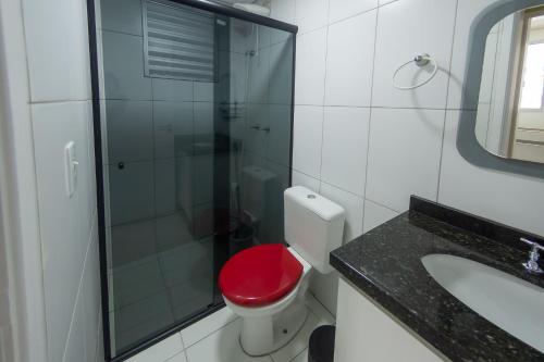 baño con aseo rojo y ducha de cristal en Apto com Wi Fi e otima localizacao em Curitiba PR, en Curitiba