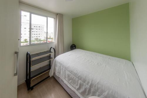 Habitación pequeña con cama y ventana en Apto com Wi Fi e otima localizacao em Curitiba PR, en Curitiba