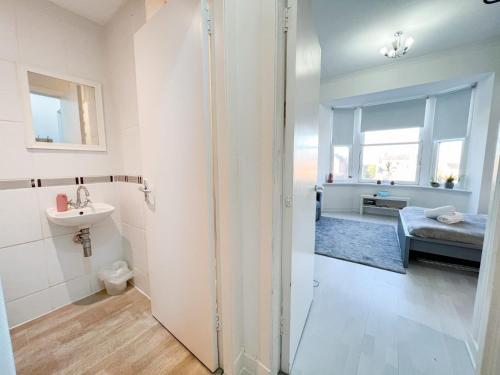 a bathroom with a shower and a sink and a bed at 1Bd Glasgow Apartment in Glasgow