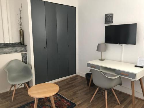 Cette chambre comprend un bureau, 2 chaises et une table. dans l'établissement Hôtel Croix Baragnon, à Toulouse