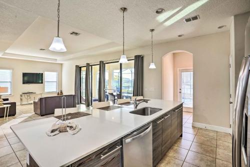 a kitchen with a sink and a living room at Modern Haines City Home with Pool and Lanai! in Haines City