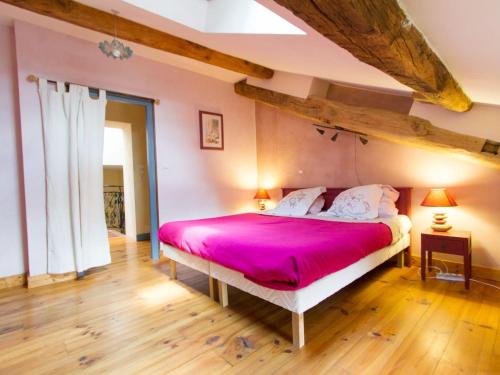 a bedroom with a large bed with a pink bedspread at Gîte de charme à Seigneulles, 3 chambres, terrasse et jardin, entre Verdun et Bar-le-Duc - FR-1-585-33 in Seigneulles