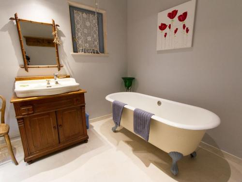 a bathroom with a bath tub and a sink at Gîte de charme à Seigneulles, 3 chambres, terrasse et jardin, entre Verdun et Bar-le-Duc - FR-1-585-33 in Seigneulles