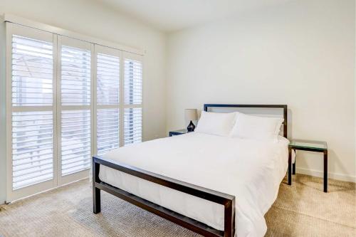 a bedroom with a large white bed and a window at Beautiful Townhome - Steps to Downtown Boise! in Boise