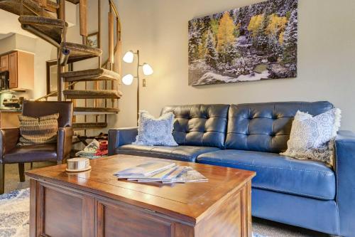 a living room with a blue couch and a wooden table at Durango Lofted Studio about 9 Mi to Purgatory Resort! in Durango