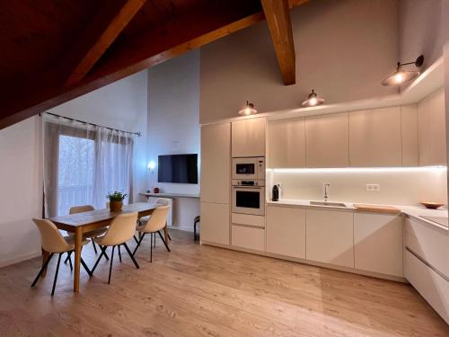 a kitchen and dining room with a table and chairs at BPIRINEOS-Ibón Blanco in Benasque
