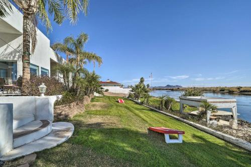 a couch and a table on the grass next to the water at Magnificent Big River Home with Beautiful Views in Parker