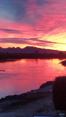 a sunset over a large body of water at Magnificent Big River Home with Beautiful Views in Parker