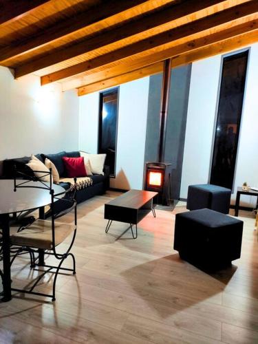 a living room with a couch and a table at Moderna Cabaña con tinaja caliente in Pirque