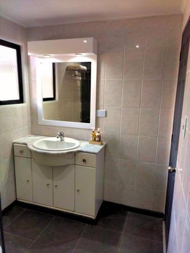 a bathroom with a sink and a mirror at Moderna Cabaña con tinaja caliente in Pirque