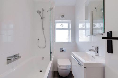 La salle de bains blanche est pourvue de toilettes et d'un lavabo. dans l'établissement Stairway To Heaven - Fitzrovia - by Frankie Says, à Londres