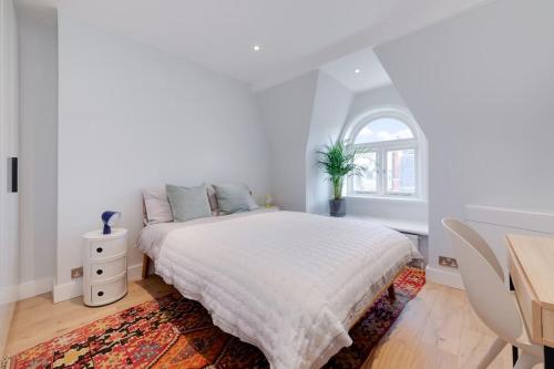 - une chambre blanche avec un lit et un bureau dans l'établissement Stairway To Heaven - Fitzrovia - by Frankie Says, à Londres