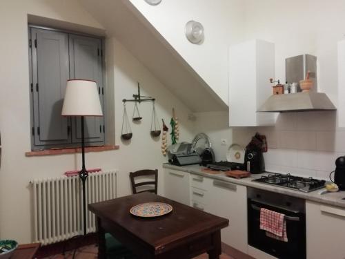 a kitchen with white cabinets and a table with a lamp at Antico Casale Il Borgo San Martino in Campo in San Martino in Campo