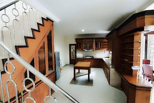 Tanjungkarang的住宿－Villa 5 BR utk Family/Grup di Villa Citra, Lampung，楼梯通往带桌子和楼梯间的厨房