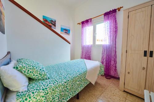 TamadusteにあるMar y Sol Casa Con Terraza y Barbacoa A 10 Metros del Marのベッドルーム1室(ベッド1台付)、紫色のカーテン付きの窓が備わります。