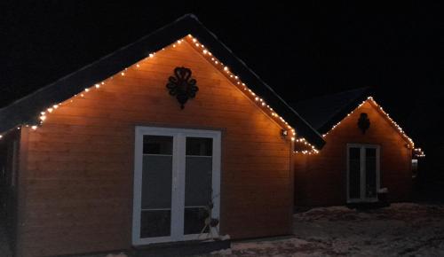 a house with christmas lights on the side of it at Spiska Dolina in Łapsze Niżne