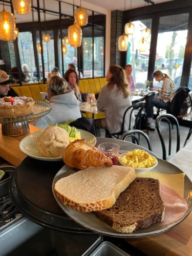 una mesa con platos de comida y gente en un restaurante en Boutique Hotel LE•BAR, en Zandvoort