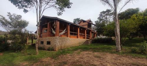 ein im Bau befindliches Haus auf einem Feld mit Bäumen in der Unterkunft Chalés Vida Verde in Bom Jardim de Minas