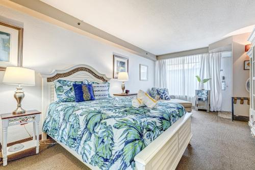 um quarto com uma cama grande com lençóis azuis e brancos em Daytona Beach Resort #215 em Daytona Beach