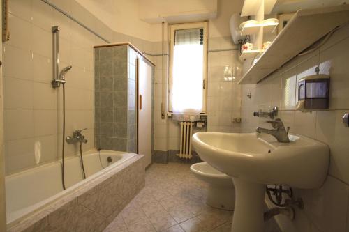a bathroom with a sink and a toilet and a tub at Enea Holiday House in Rome