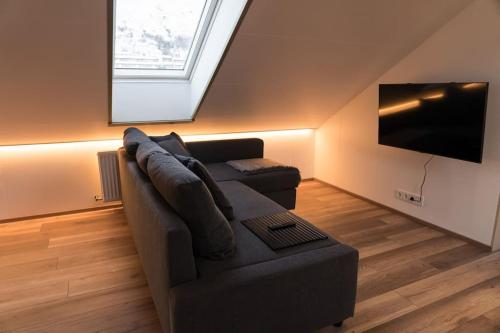 a living room with a couch and a flat screen tv at Scenic Penthouse - Ocean view & skylight windows in Siglufjörður