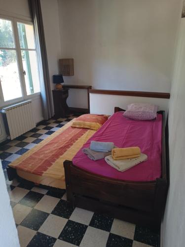 een slaapkamer met een bed met roze lakens en handdoeken bij VILLA AVEC PISCINE A 400M DE LA PLAGE in Sanary-sur-Mer