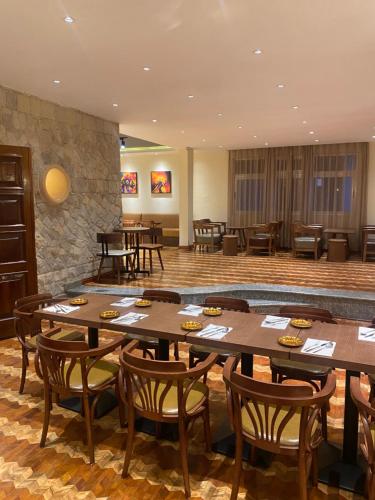 Un restaurante con mesas y sillas de madera en una sala. en Social House, en Addis Ababa