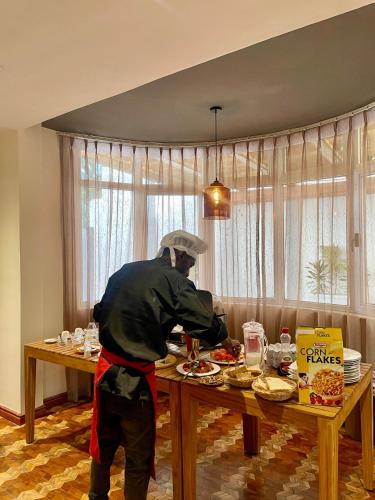 un hombre de pie en una mesa preparando comida en Social House, en Addis Ababa