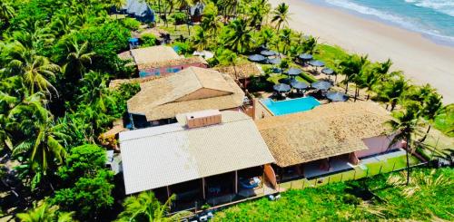an aerial view of a resort on the beach at Pousada Luar da Praia in Imbassai