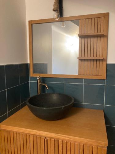 une salle de bain avec un lavabo noir et un miroir dans l'établissement Chambre triple proche plage, à Lancieux