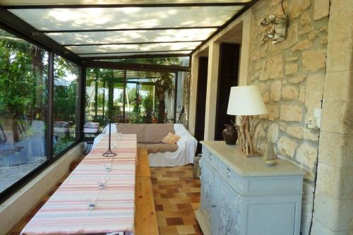 d'une terrasse avec une table et un canapé sur un balcon. dans l'établissement Maison de 6 chambres avec piscine privée, jardin aménagé et wifi à Pernes-les-Fontaines, à Pernes-les-Fontaines