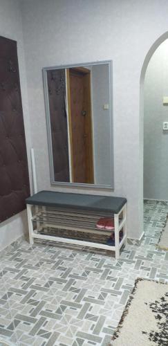 a bathroom with a mirror and a bench on a tile floor at MamaiaApart in Lupeni