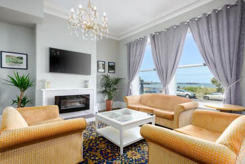 a living room with two chairs and a fireplace at Somerset Hotel in Llandudno