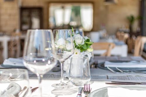 a table with wine glasses and a vase of flowers at Masseria dei Monaci in Otranto