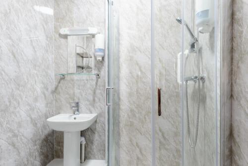 a bathroom with a sink and a shower at Somerset Hotel in Llandudno