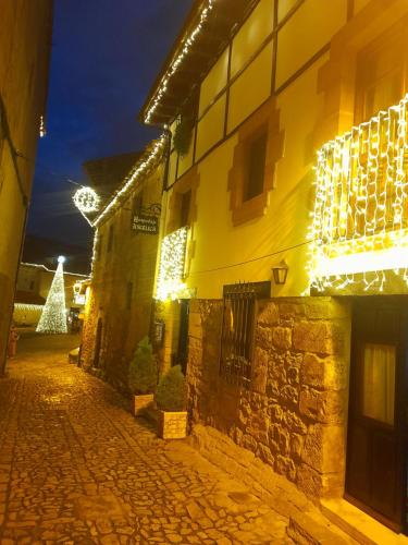 a building with christmas lights and a christmas tree at Hospedaje Angelica in Santillana del Mar