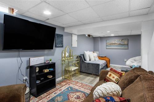 ein Wohnzimmer mit einem Flachbildfernseher an der Wand in der Unterkunft Boho cozy home, quiet, free parking (private room unless specified) in Kalamazoo