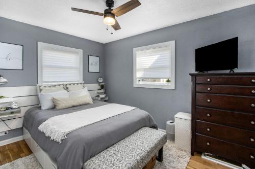 um quarto com uma cama e uma cómoda com uma televisão em Boho cozy home, quiet, free parking (private room unless specified) em Kalamazoo
